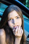 Beautiful teen girl models in the nude on passenger seat of car with door open