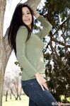 Latina chick Bella Quinn climbs a tree in the park wearing a sweater and jeans