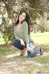 Latina chick Bella Quinn climbs a tree in the park wearing a sweater and jeans