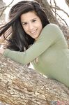 Latina chick Bella Quinn climbs a tree in the park wearing a sweater and jeans
