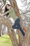Latina chick Bella Quinn climbs a tree in the park wearing a sweater and jeans