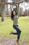 Latina chick Bella Quinn climbs a tree in the park wearing a sweater and jeans