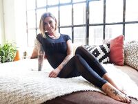 Tattooed girl Kleio Valentien bares round tits as she gets naked on bed