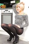 Short haired blonde Naomi K goes topless in a kitchen wearing pantyhose