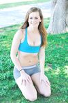 Fitness girl in shorts undressing to show her big tits outdoors