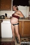 Pregnant amateur removes a tube top before slipping out of sexy panties