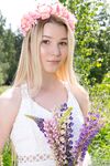 Young blonde wears a crown of flowers during her nude debut amid fireweed