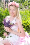 Young blonde wears a crown of flowers during her nude debut amid fireweed