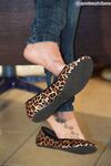 Solo model Valeria removes flat shoes from bare feet while fully clothed