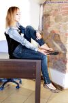Solo model Valeria removes flat shoes from bare feet while fully clothed