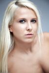 Blonde girl with long hair and medium breasts models in the nude