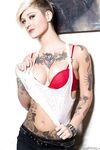 Tattooed model Kleio Valentien takes off clothes and boots to model naked