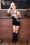 Gorgeous petite blonde barista poses on the cafe counter topless in boots