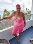 Fat nan with short red hair finger spreads her pussy on oceanside balcony