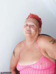 Fat nan with short red hair finger spreads her pussy on oceanside balcony