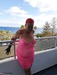 Fat nan with short red hair finger spreads her pussy on oceanside balcony