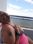 Fat nan with short red hair finger spreads her pussy on oceanside balcony