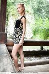 Beautiful teen girl exposes her thin body and on log platform in nature