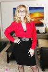 Granny in glasses Nina Hartley reveals her nice juggs and poses in lingerie