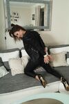 Fully clothed female is tied up with rope in leather attire paired with heels
