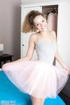 Tiny teen Faina removes tutu and onesie to model naked on her bed