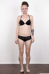 Pierced and tattooed amateur Petra stands naked after removing her clothes