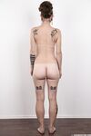 Pierced and tattooed amateur Petra stands naked after removing her clothes