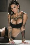 Inked MILF in glasses Bonnie Rotten uncovers her magnificent tits in a solo