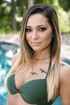 Thin teen girl Jaye Summers takes off her bikini on a patio beside a pool