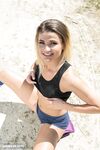 Fit girl Zora removes athletic socks to finish getting naked by the water