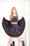 Striking redhead Jayme wearing dress and heels flashes appealing naked pussy