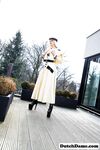 Classy blonde flashes the village below on her patio in latex attire