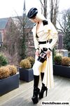 Classy blonde flashes the village below on her patio in latex attire