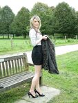 Leg model poses on a country bench in black skirt and pumps