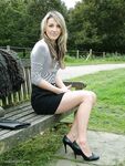 Leg model poses on a country bench in black skirt and pumps