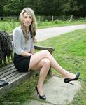 Leg model poses on a country bench in black skirt and pumps
