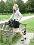 Leg model poses on a country bench in black skirt and pumps