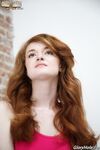 Leggy redhead cheater Abbey Rain strips while watching porn in gloryhole room