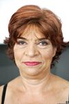 Mature redhead granny Donatella cooks in the kitchen wearing black lingerie