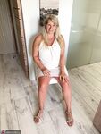Thick older woman Sweet Susi exposes tan lined tits after hiking up her dress