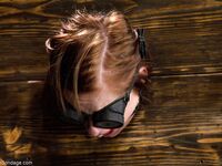 Gagged slave Charlie Ann cuffed in the pillory for naked BDSM ass whipping