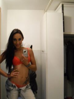 Teen with an inked body Ella Storm takes selfies while stripping in the mirror