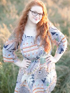Hot redhead BBW Kaycee looses her huge tits and gets on her knees in a field