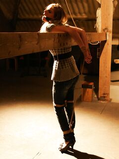 Cute blonde girl struggles against gag and ropes with her clothes still on