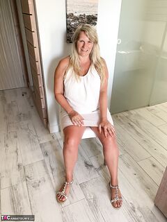 Thick older woman Sweet Susi exposes tan lined tits after hiking up her dress